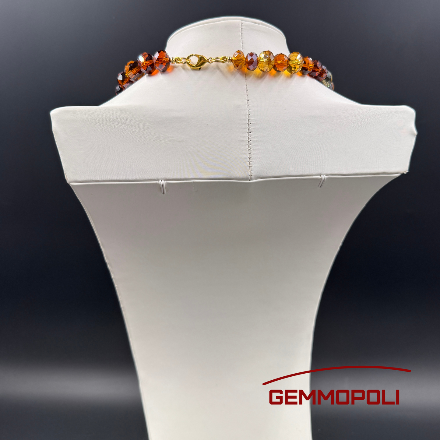 Dettaglio chiusura dorata collana cristalli color miele e ambra con pietre nere naturali