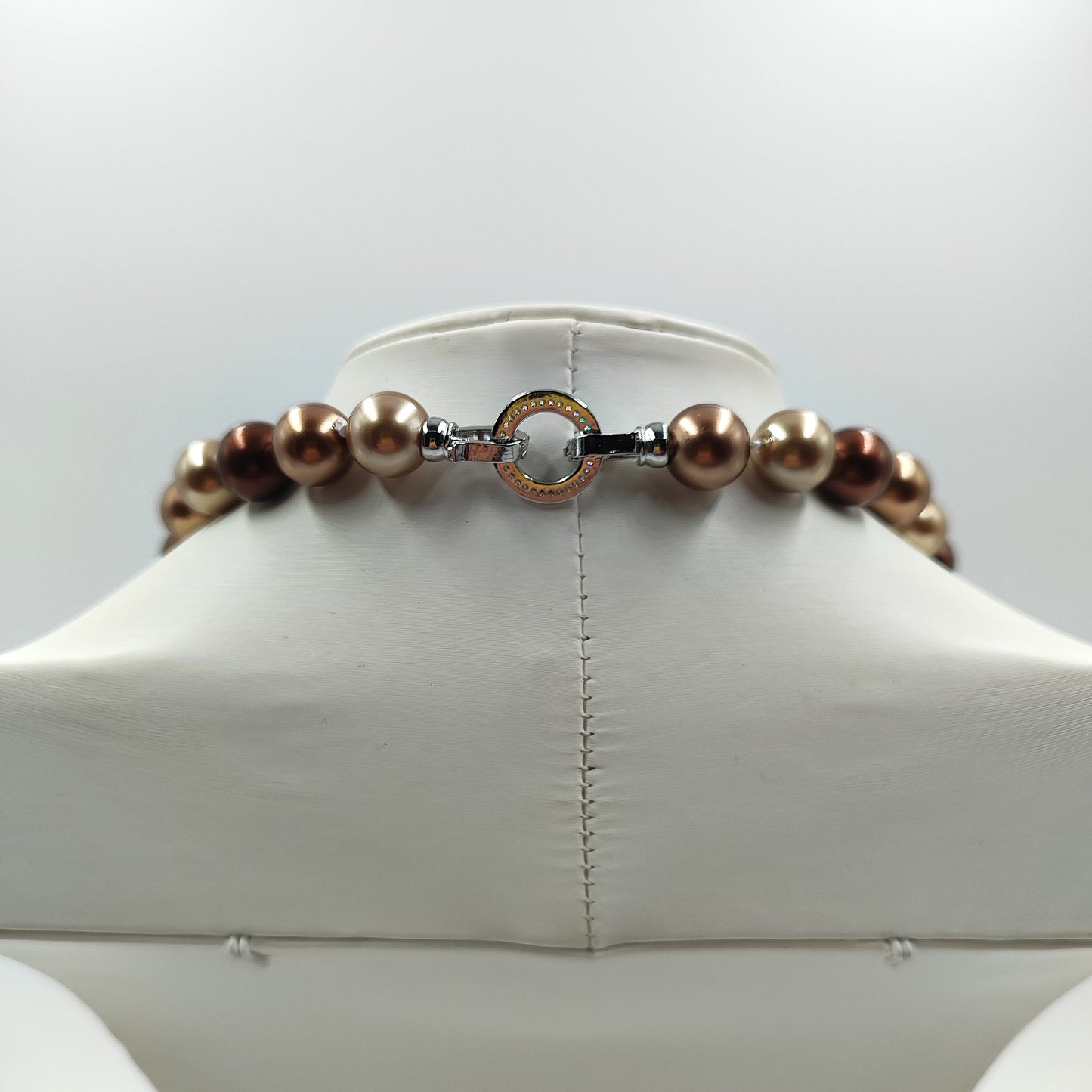 Dettaglio della chiusura della collana perla marrone da 12mm che mostra l'uniformità e la lucentezza.