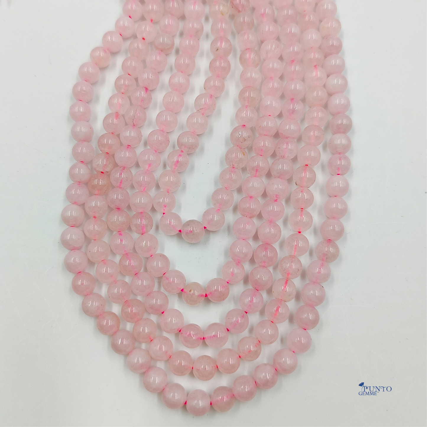 Dettaglio macro di una perla di Quarzo Rosa 6mm, che evidenzia la traslucidità e la texture lattiginosa.
