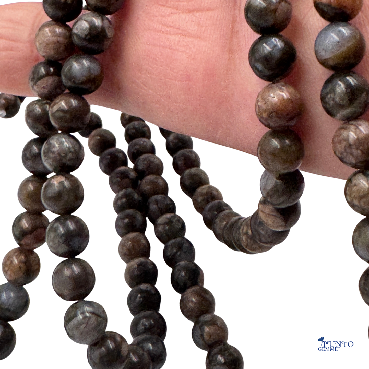 Dettaglio ravvicinato delle perle in Glaucofane (PE0925-06) di 6 mm, che evidenzia la finitura lucida e la trama opaca del minerale.