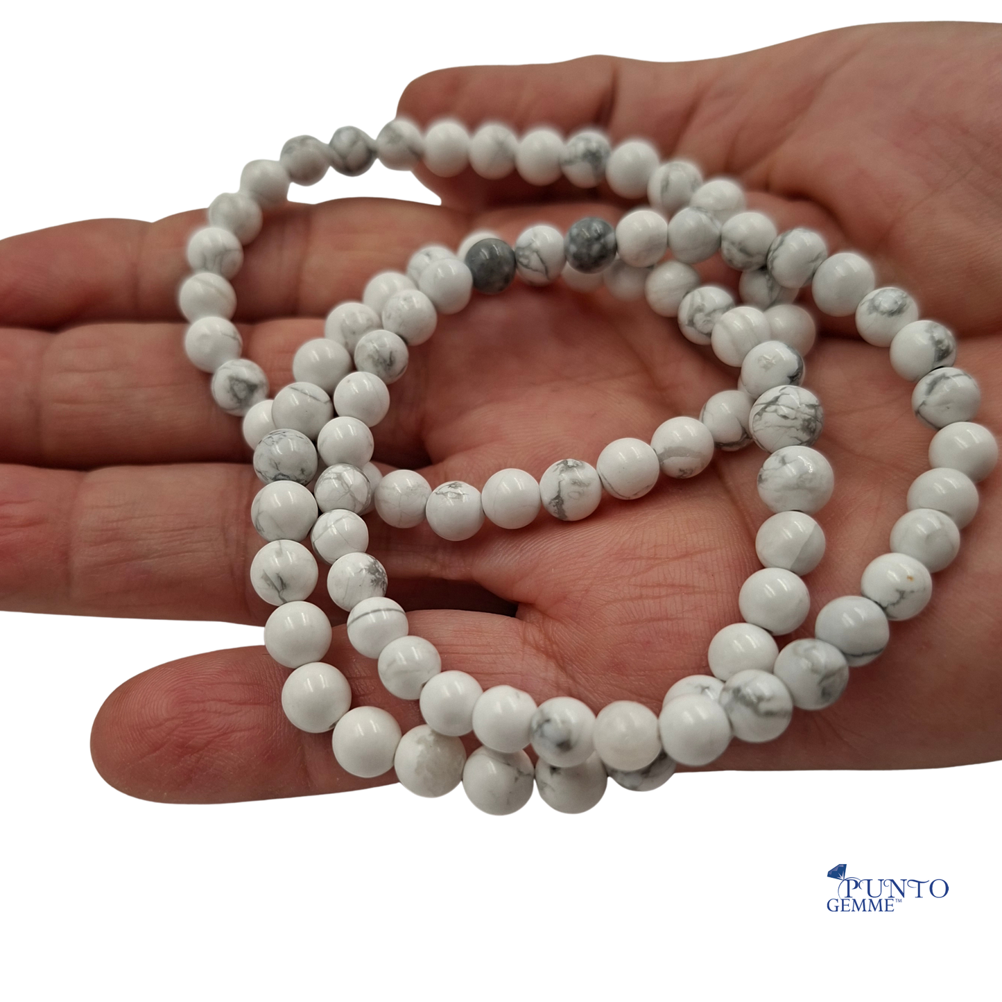 Dettaglio ravvicinato delle perle di Howlite Bianca , che mostrano l'uniformità del colore e la venatura naturale.