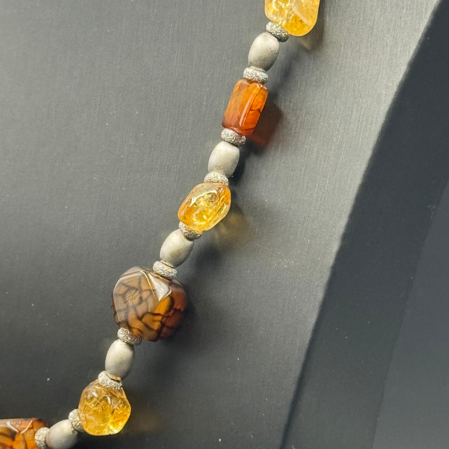 Dettaglio ravvicinato della sinergia tra Quarzo Citrino lucido e Agata, combinazione di fuoco e terra nella Collana A0005.