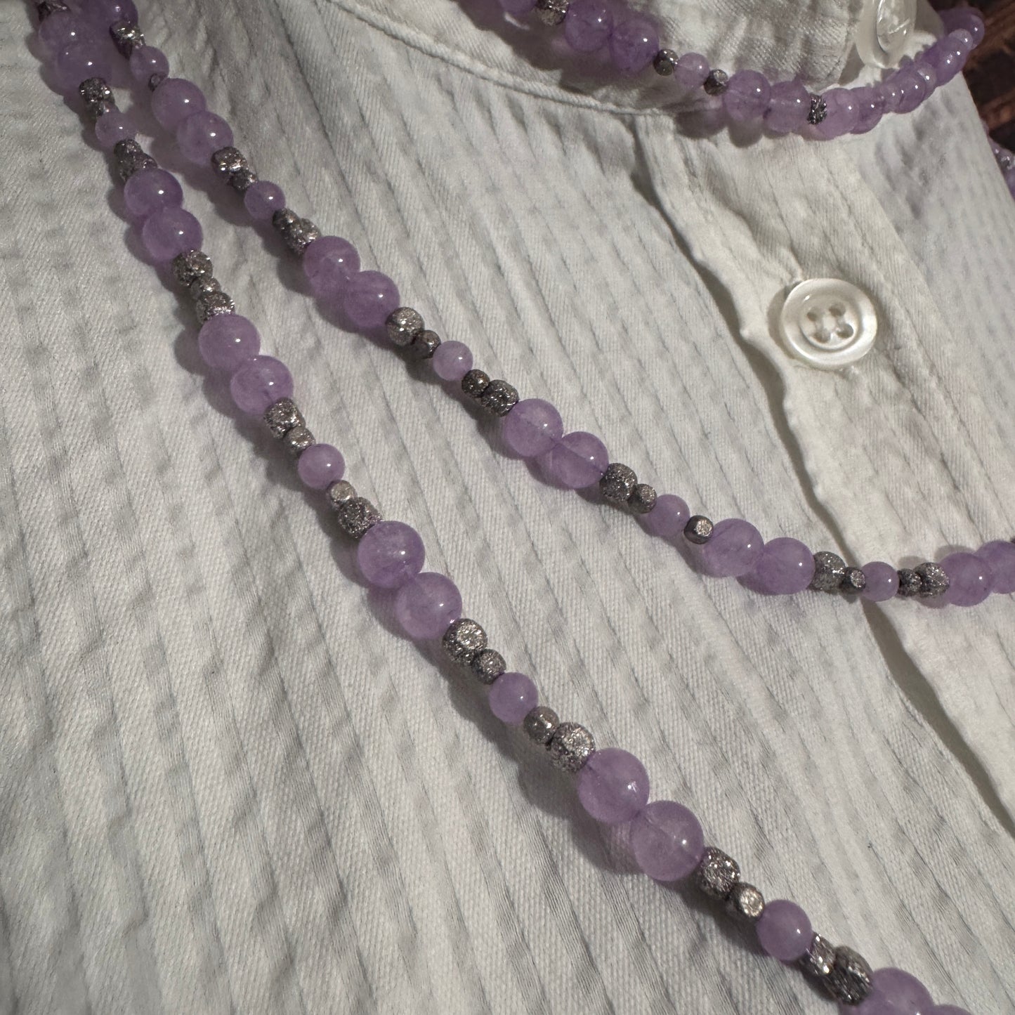 Dettaglio ravvicinato delle perle di Ametista Lavanda, evidenziando la delicata tonalità viola e la brillantezza degli spaziatori.