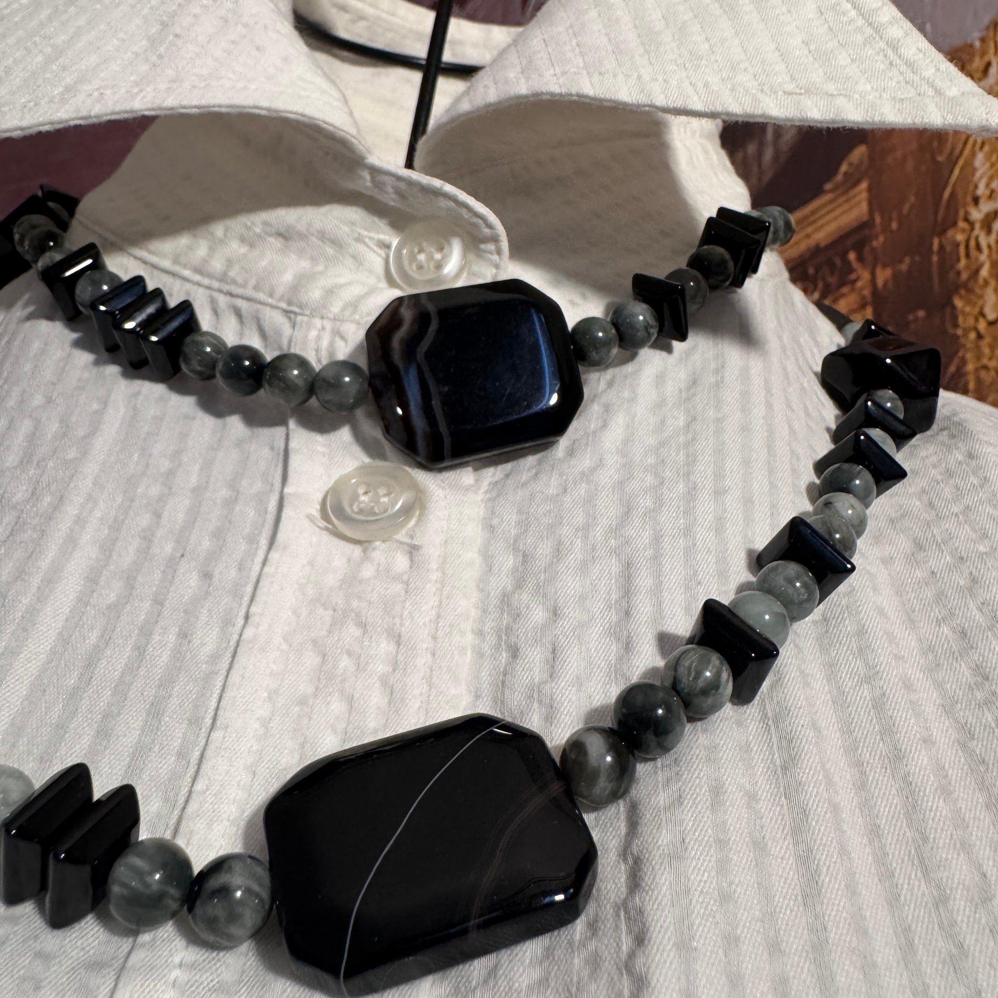 Dettaglio ravvicinato della sinergia tra l'Occhio di Falco chatoyante e l'Onice Nero  nella collana A0016.