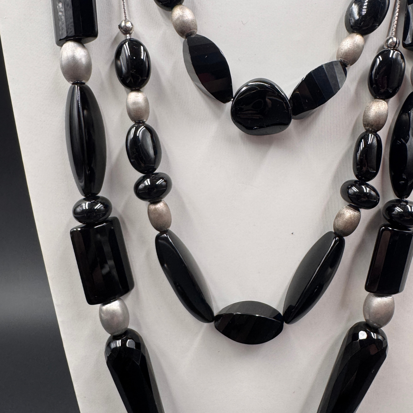 Dettaglio ravvicinato delle perle nere (Onice e Agata) che mostrano la varietà di forme e la finitura lucida delle pietre.