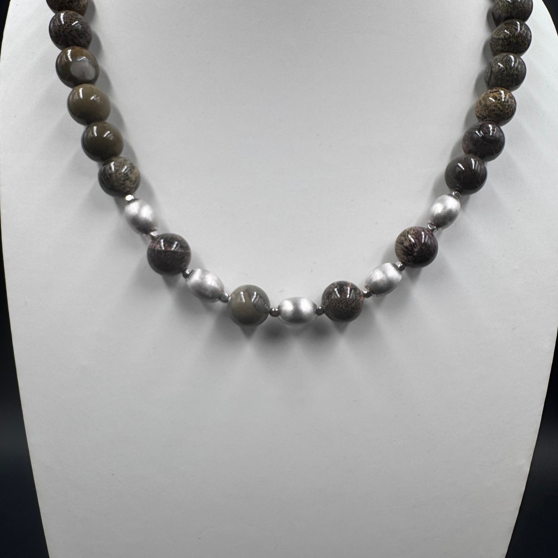 Dettaglio ravvicinato delle perle di Diaspro Artico, evidenziando le venature scure e la finitura delle ovaline setate.