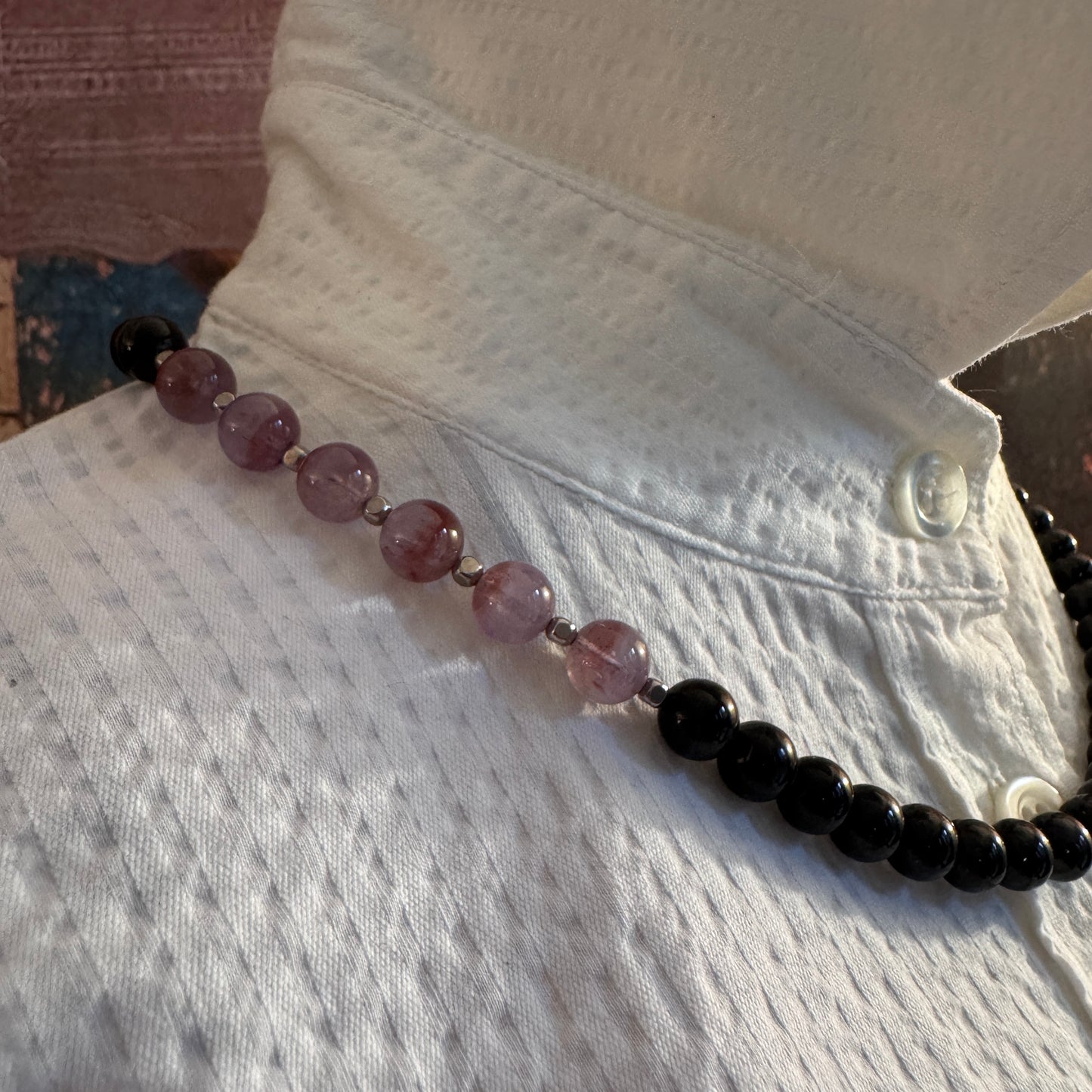 Collana Girocollo Guy Favia (A1033) in Onice Nero e Auralite 23, che mostra l'armonia tra il nero lucido e i toni viola della Pietra del Risveglio.