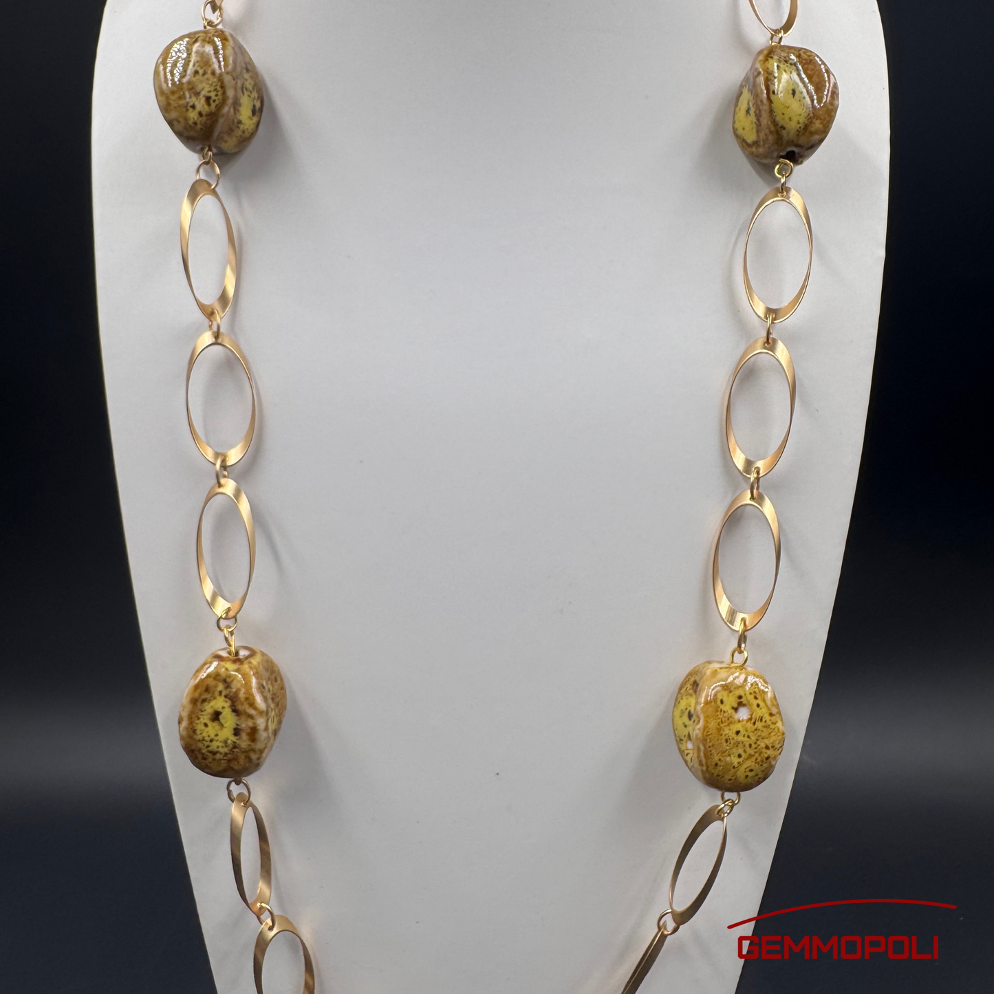 Dettaglio catena dorata e perle in porcellana ocra e marrone 