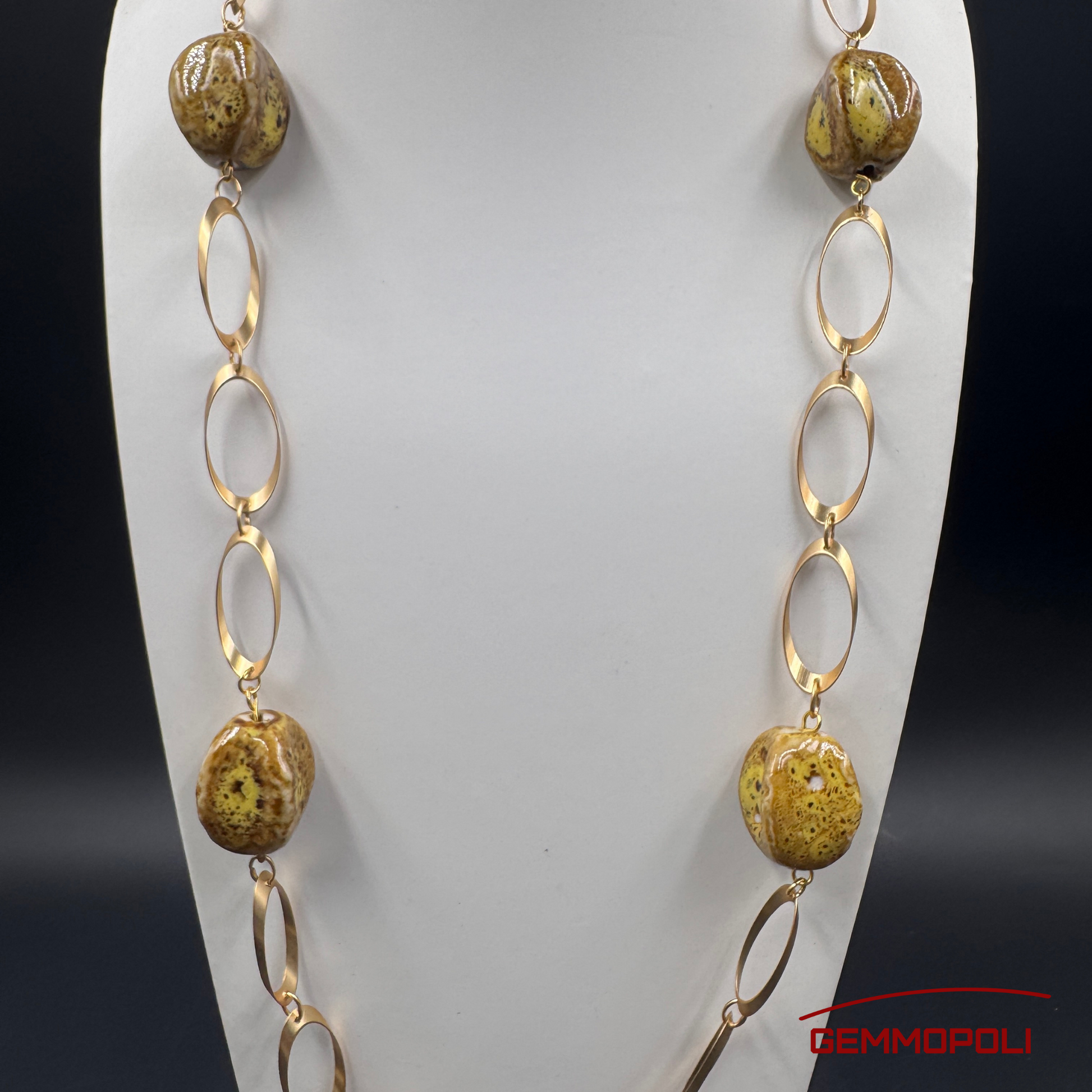 Dettaglio catena dorata e perle in porcellana ocra e marrone 