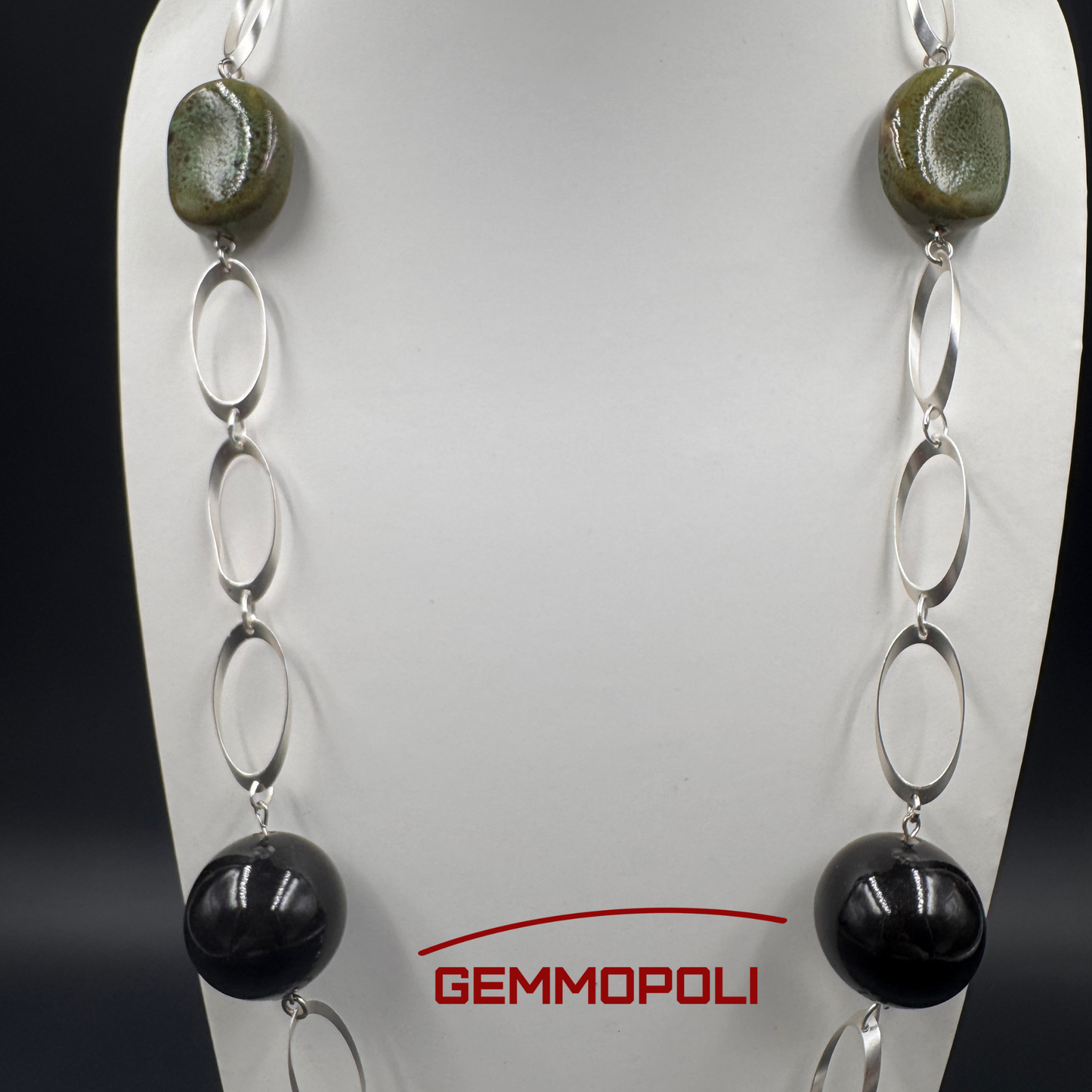 Dettaglio catena argentata e perle in porcellana verde e nera 