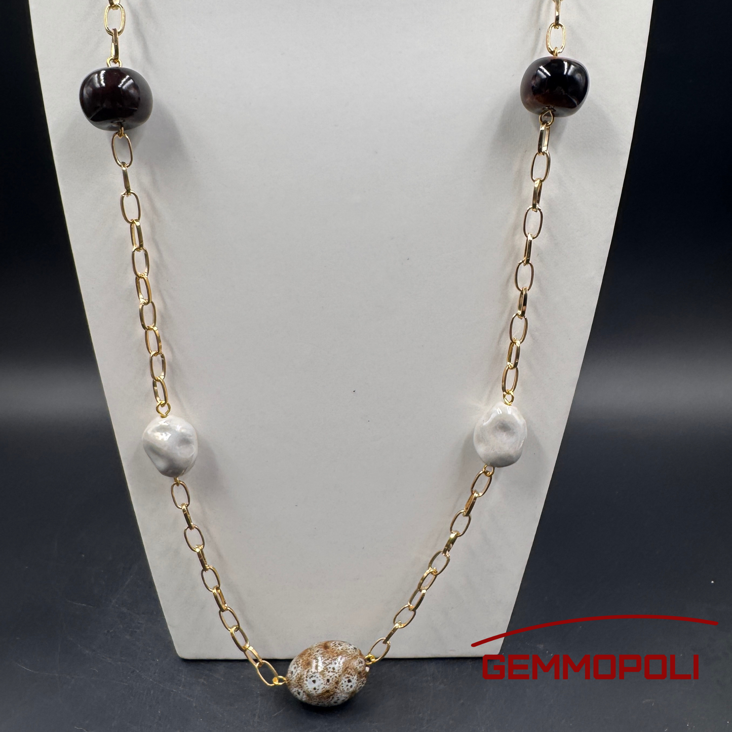 Particolare di sfere di porcellana smaltata in bianco e marrone su catena oro – Gemmopoli