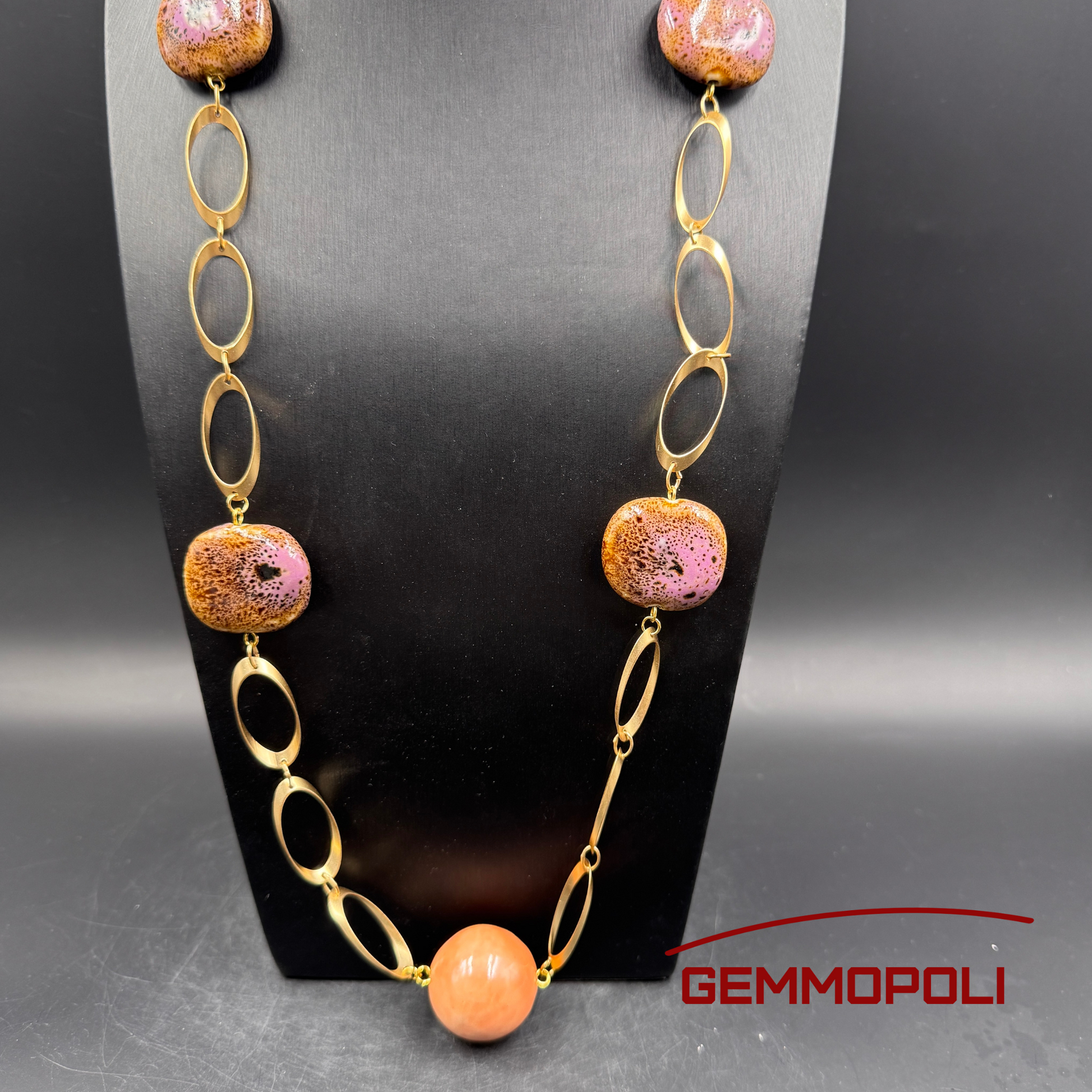 Dettaglio catena oro e perle in porcellana rosa smaltata su collo nero