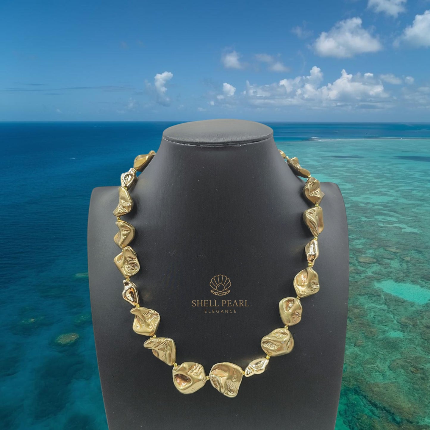 Collana barocca bronzo e oro in perle di conchiglia, vista caraibi, mare.