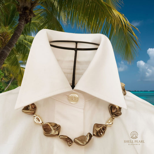 Composizione artistica perle di conchiglia color bronzo e oro ccon palme tropicali.