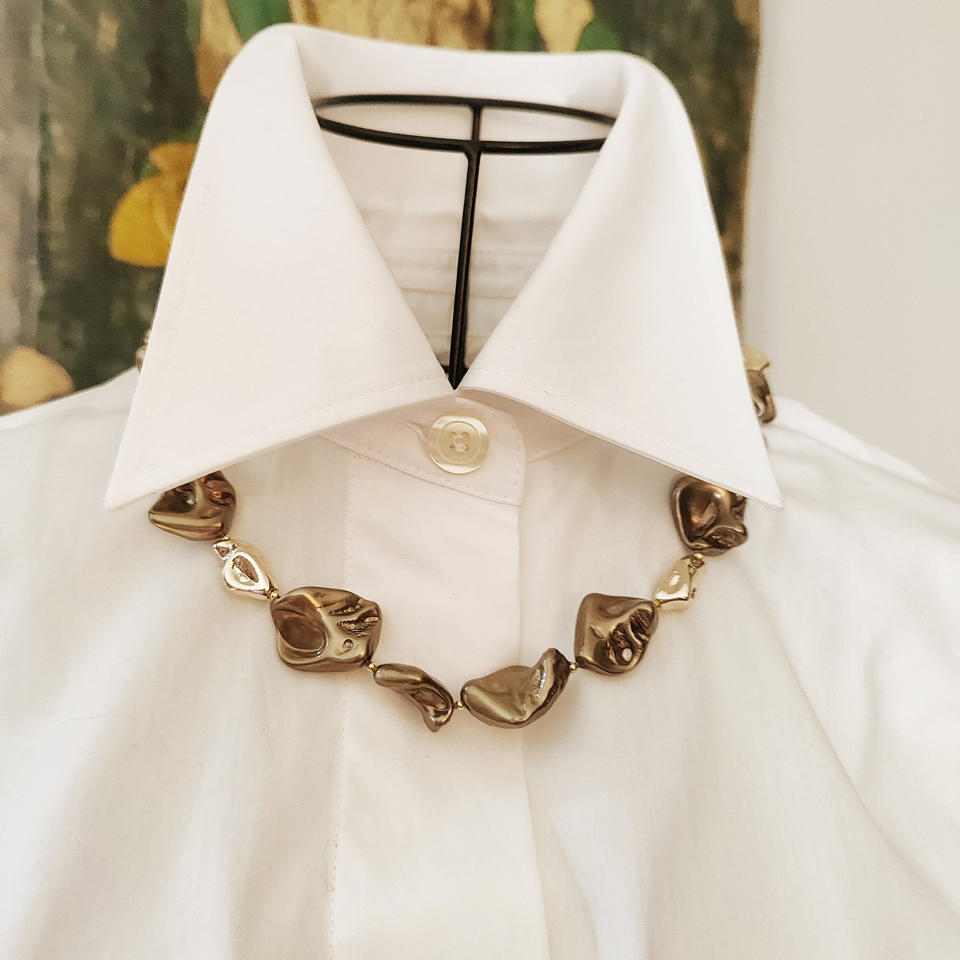 Perle scultura color bronzo e perle oro, dettaglio che evidenzia la ricca tonalità. 