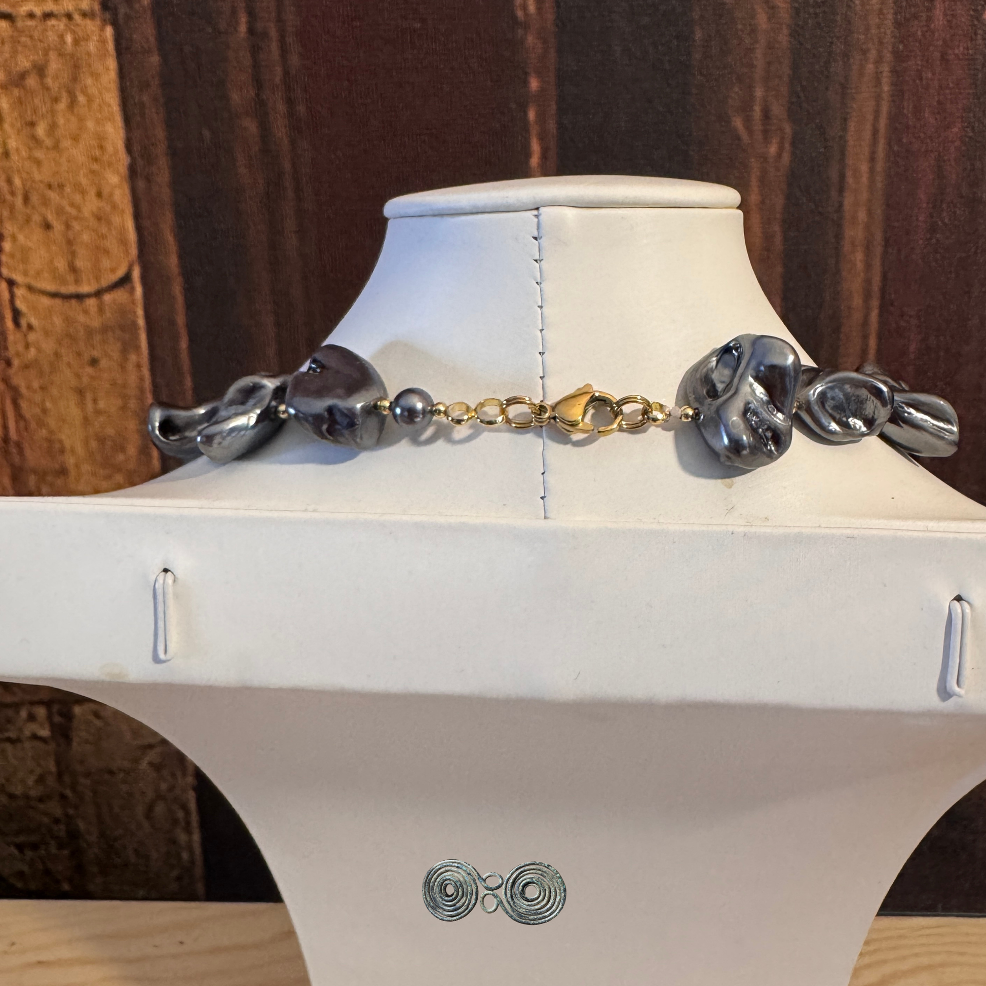 Chiusura dorata e particolari della finitura antracite della collana GA0022.