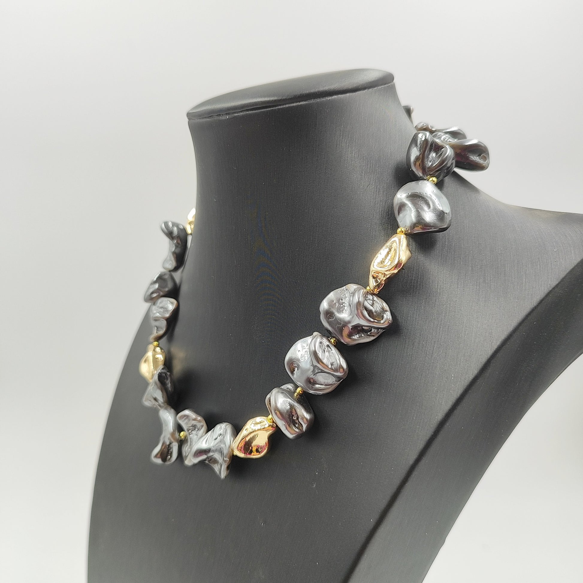 Gioiello moderno in perle scultura grigie e perle dorate, ideale per look audaci. 