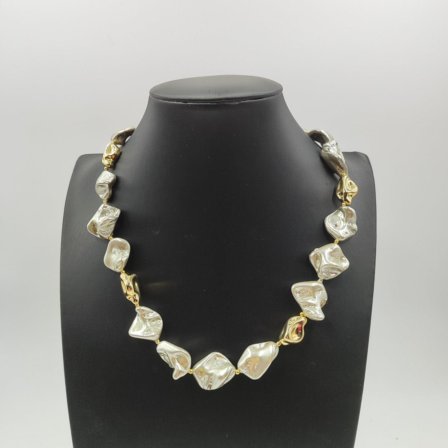 Gioiello moderno grigio chiaro ed elegante con perle dorate