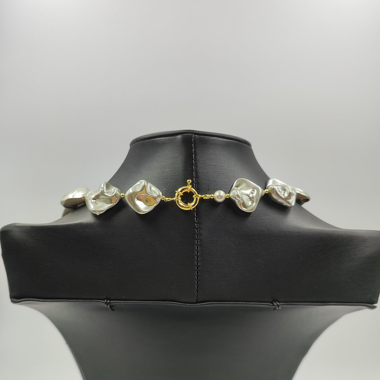 Chiusura in ottone della collana con perle barocche grigio chiaro e nucleo in madreperla, abbinate a perle oro. 