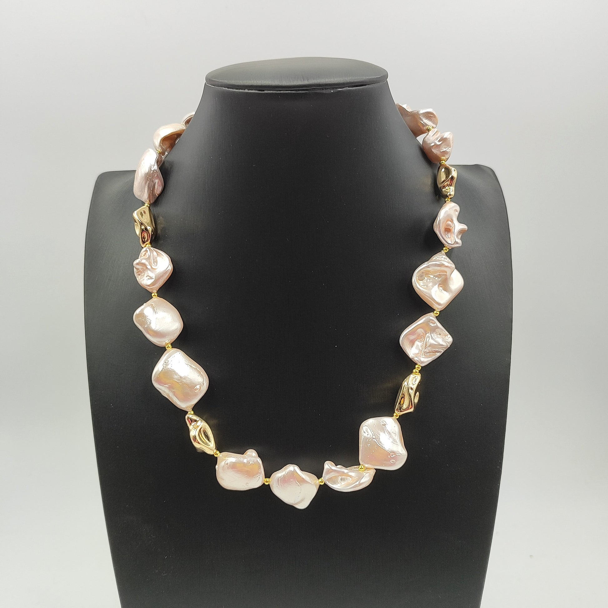 Perle irregolari rosa lucide, con nucleo in madreperla e perle dorate. 