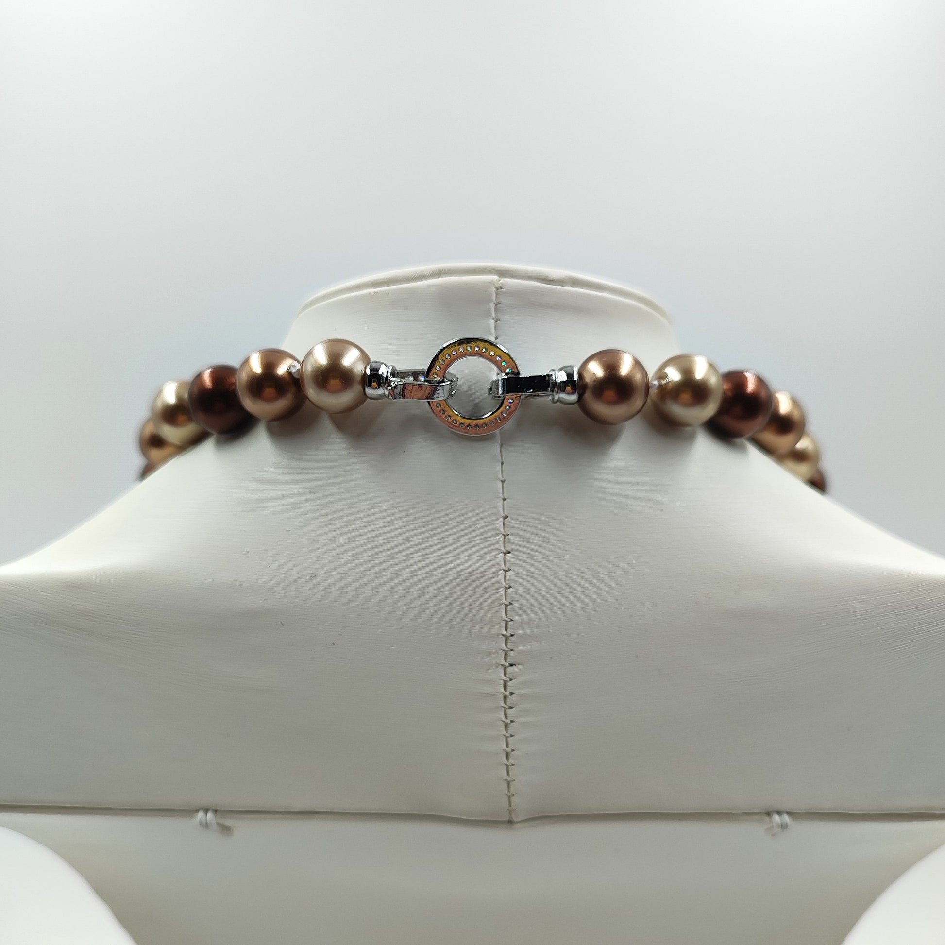 Dettaglio della chiusura della collana perla marrone da 12mm che mostra l'uniformità e la lucentezza. 