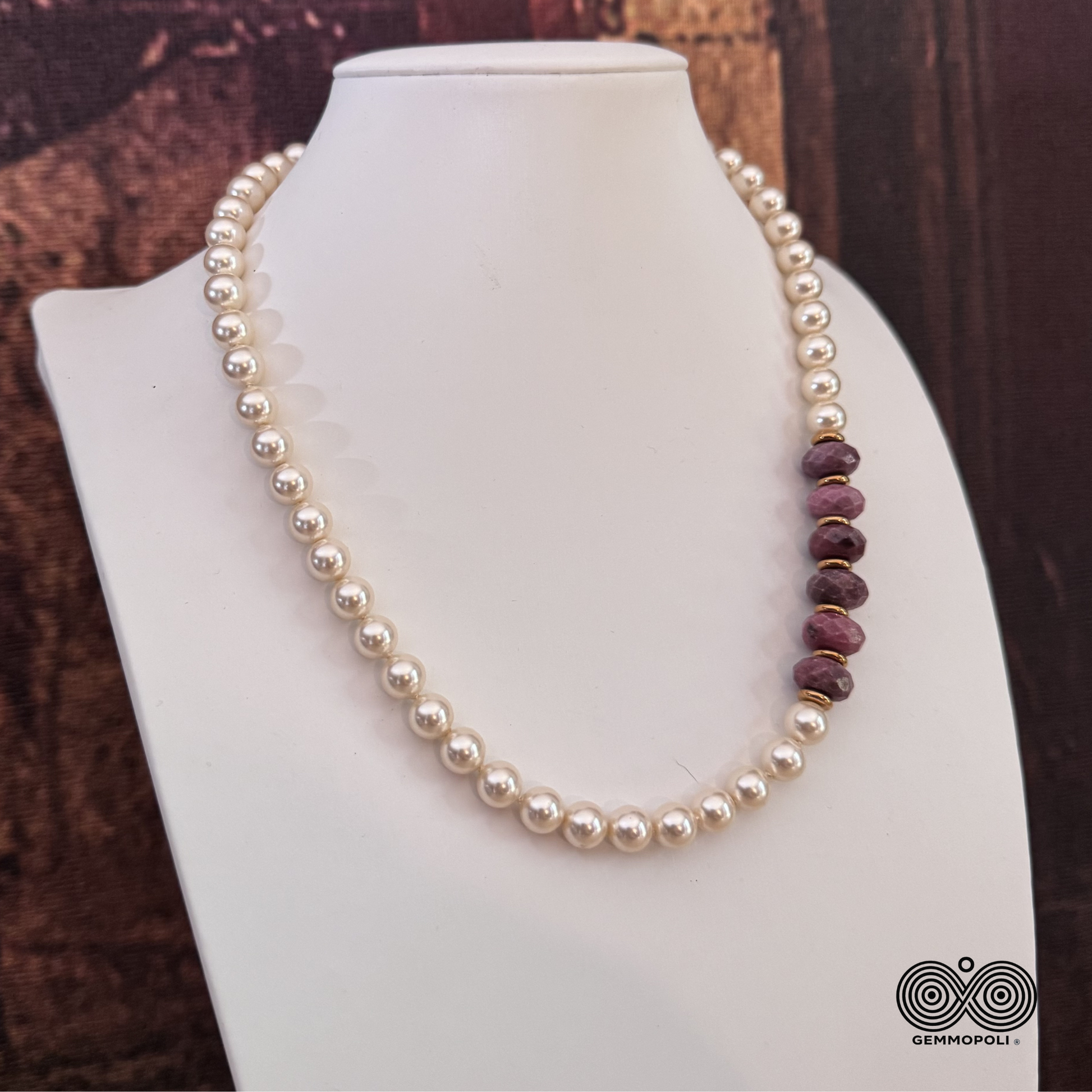 Dettaglio macro delle rondelle sfaccettate di rodonite rosa e perle di madreperla con chiusura oro