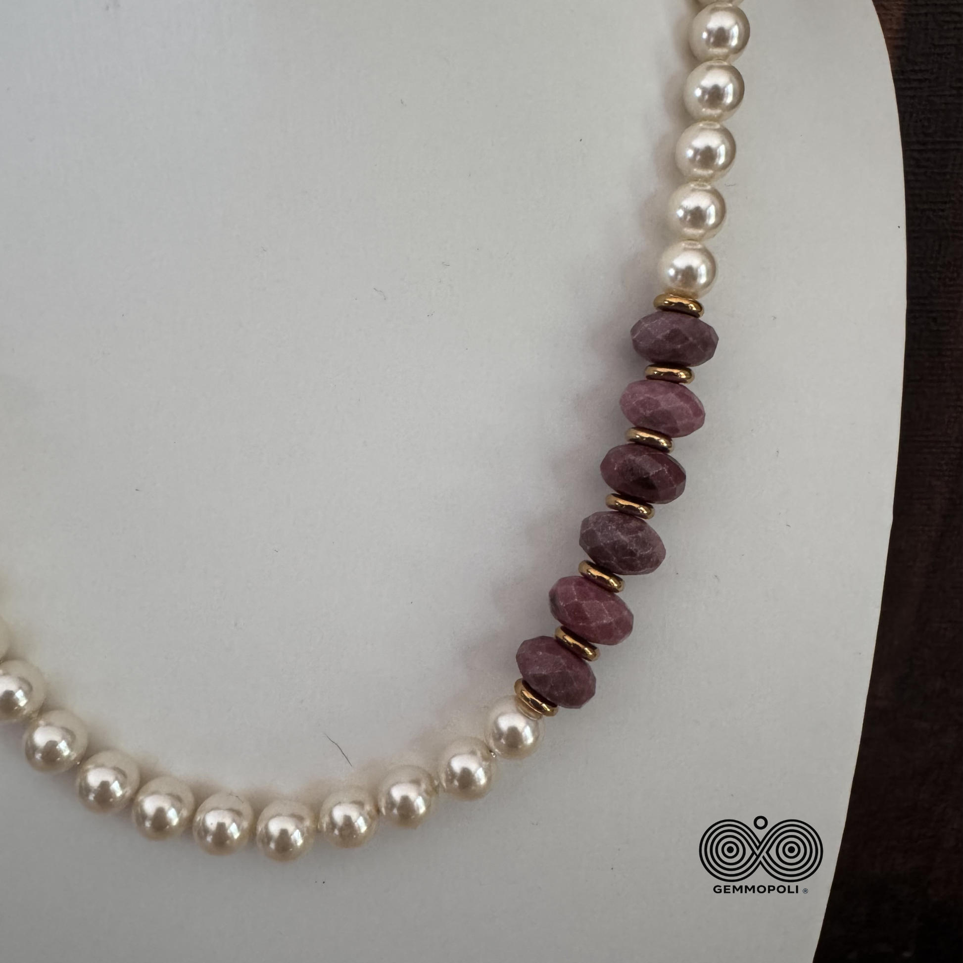 Zoom  delle rondelle sfaccettate di rodonite rosa e perle di madreperla con chiusura oro