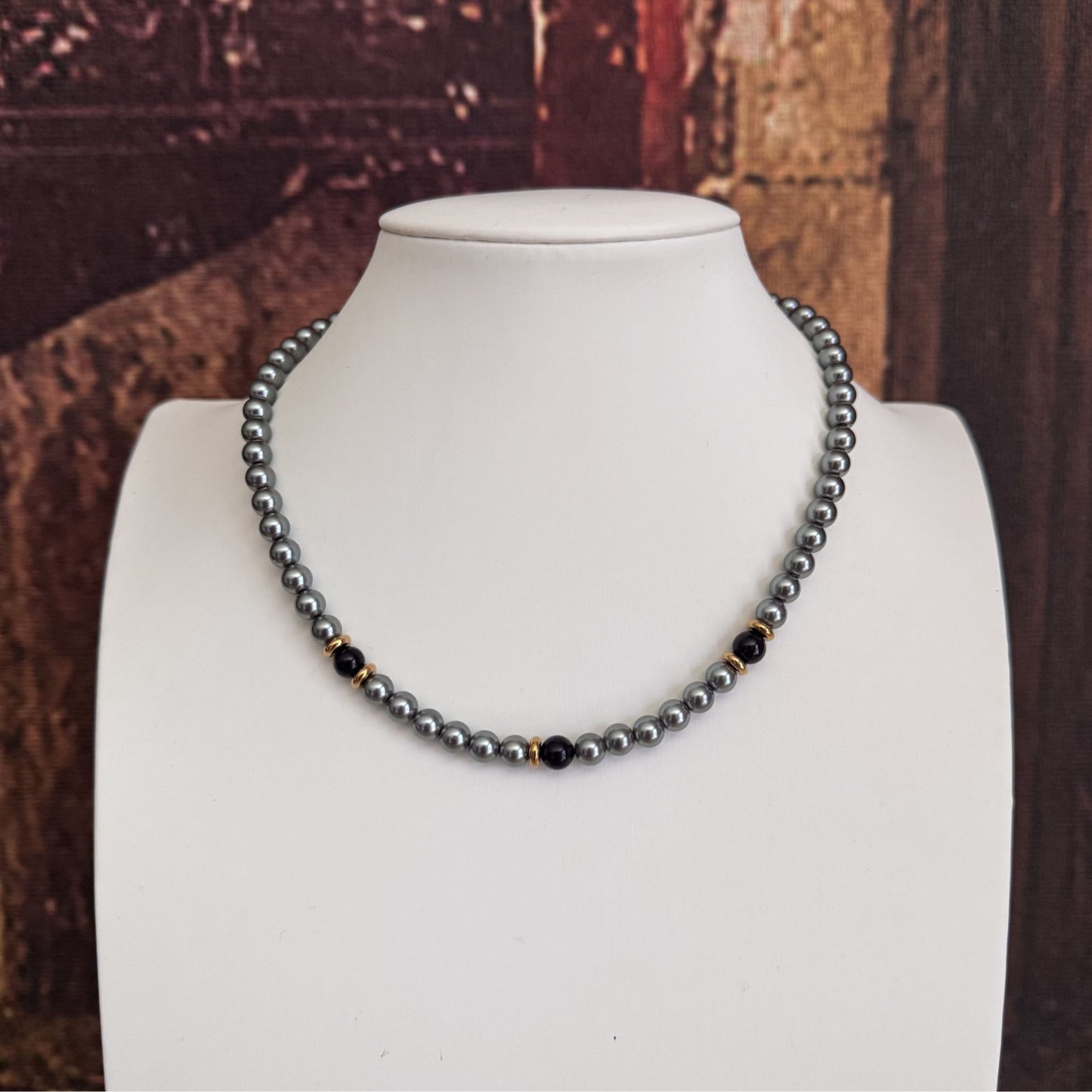 Collana elegante grigia con perle nere e acciaio dorato 