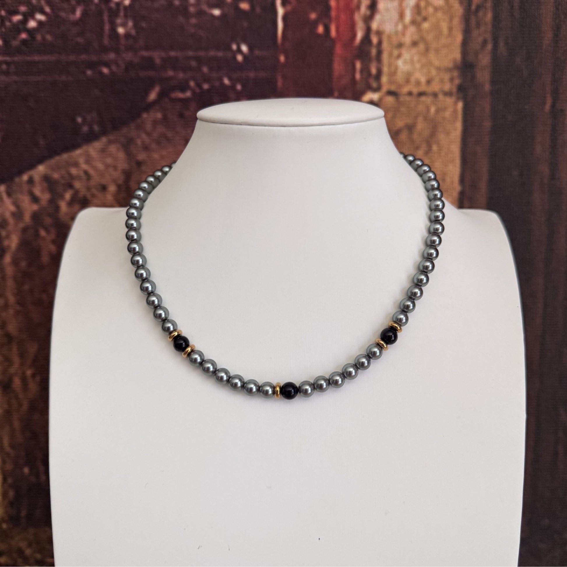 Collana elegante grigia con perle nere e acciaio dorato 