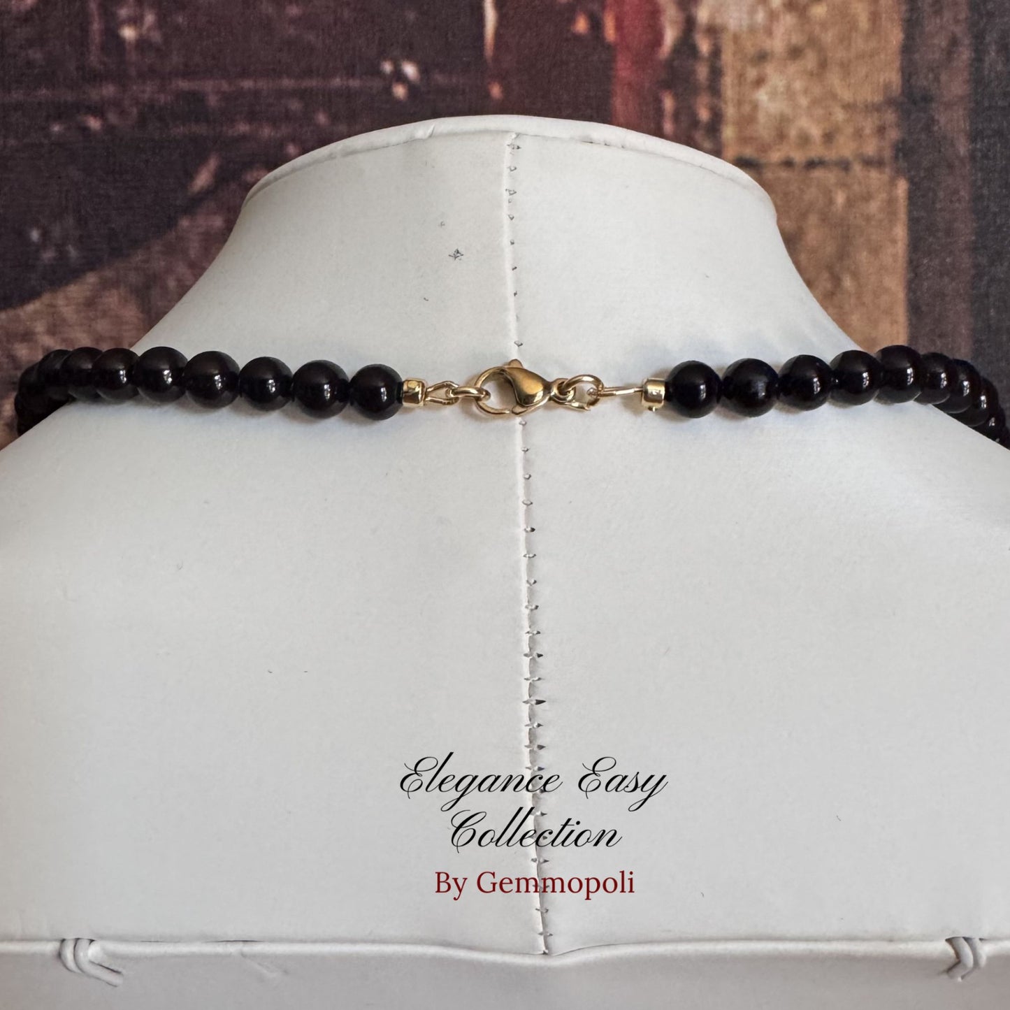 Chiusura acciaio della collana  nera perle elegance con dettagli oro e perle rosse centrali 