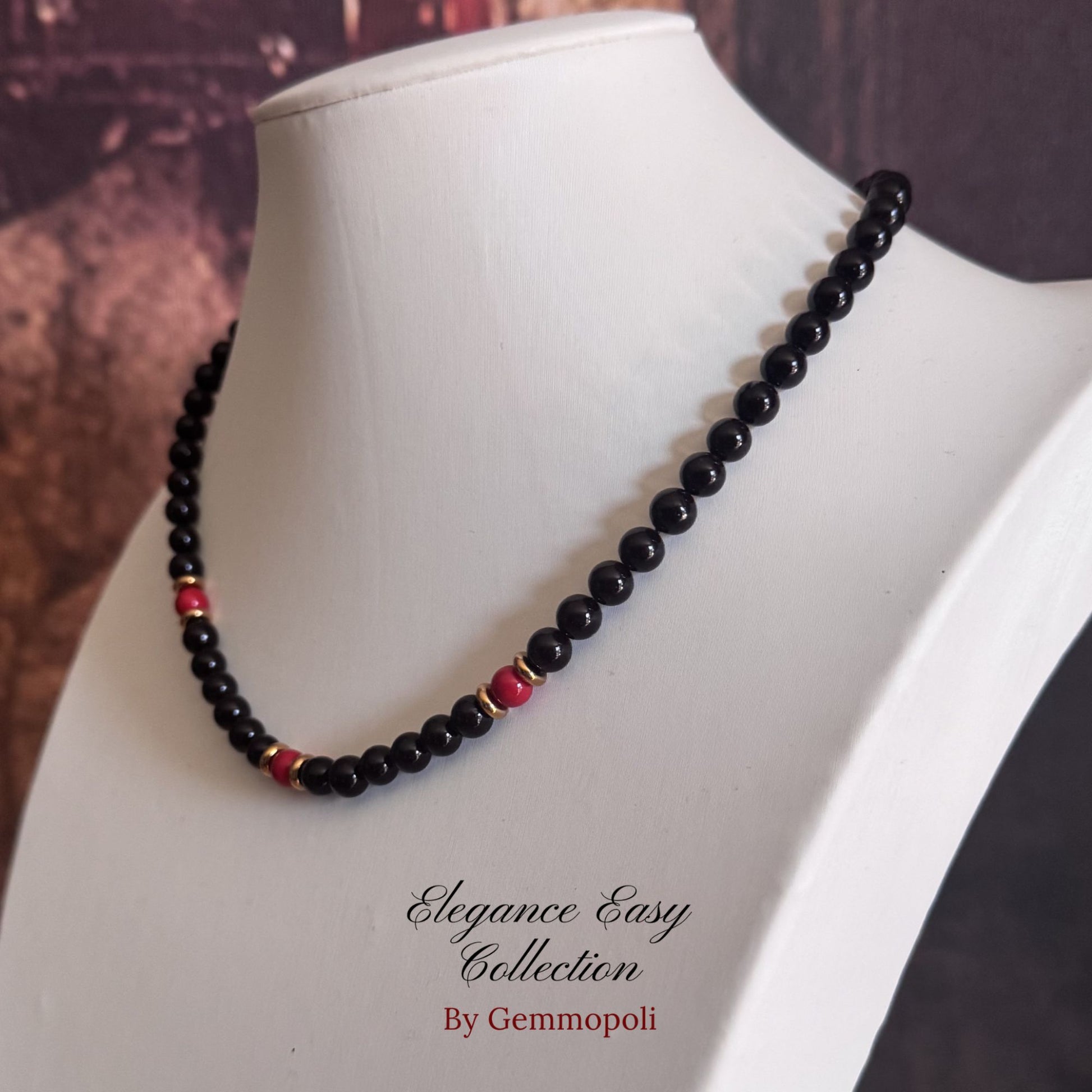 Collana elegante nera con perle rosse e acciaio dorato 
