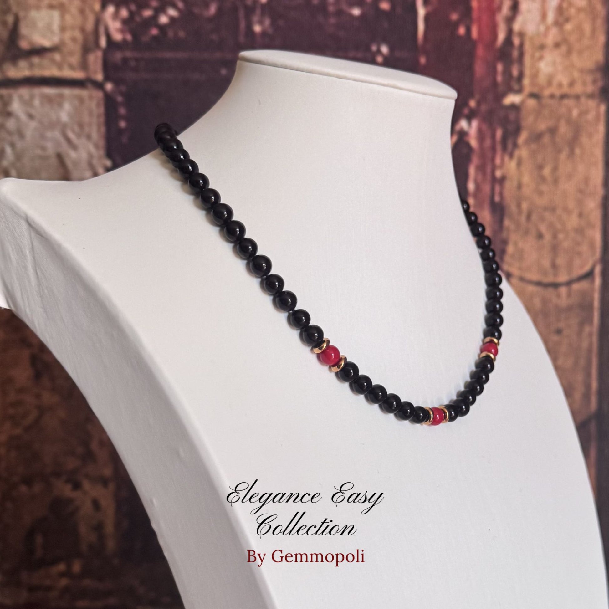 rocollo nero perle elegance con dettagli oro e perle rosse centrali 