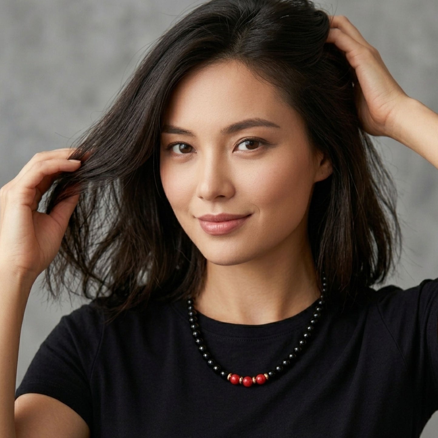 Modella che indossa Girocollo nero perle elegance con dettagli oro e perle rosse centrali GA0056