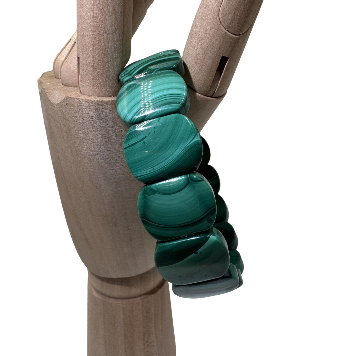 Gioiello materico in malachite verde scuro taglio geometrico moderno.