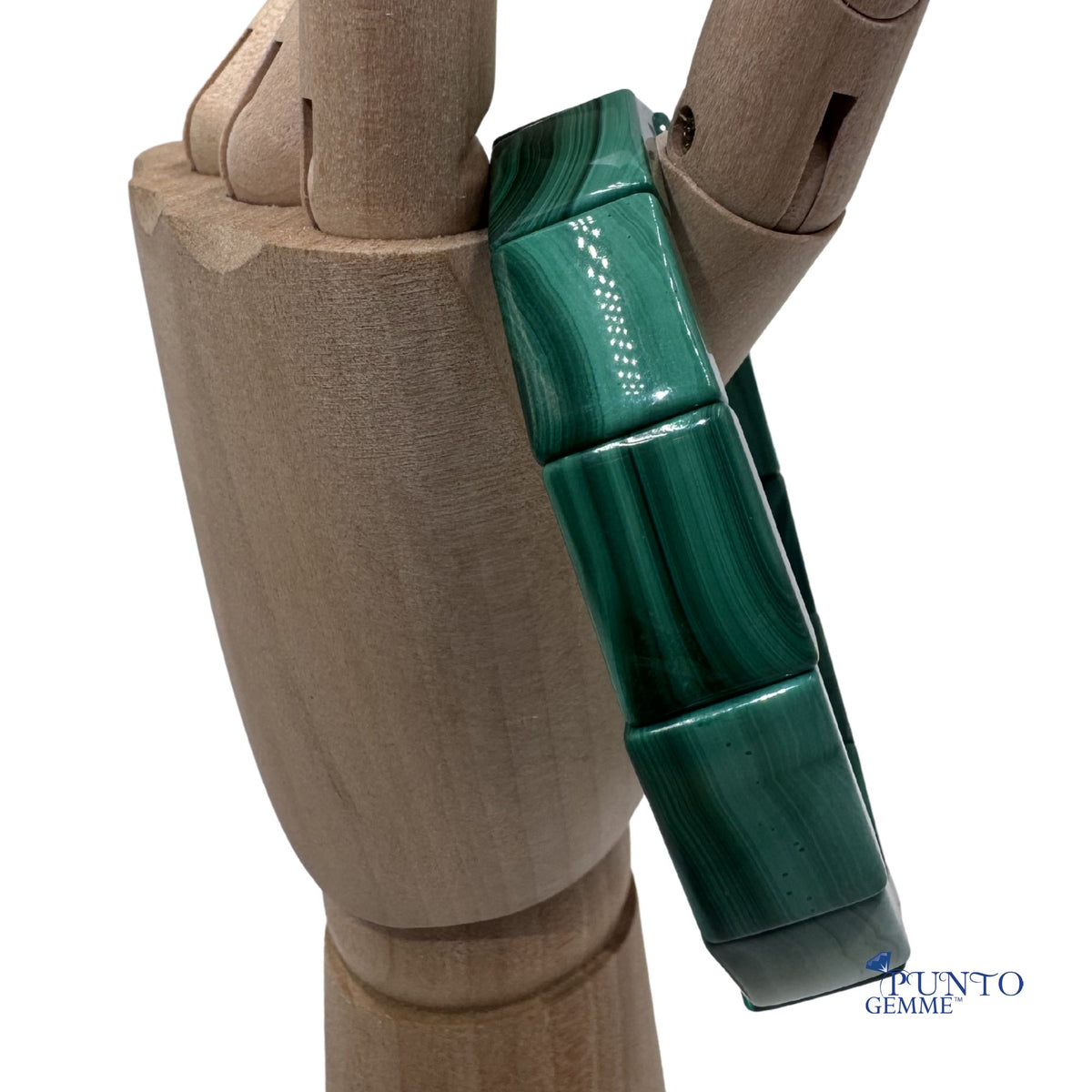 Gioiello materico in malachite verde scuro taglio geometrico moderno.