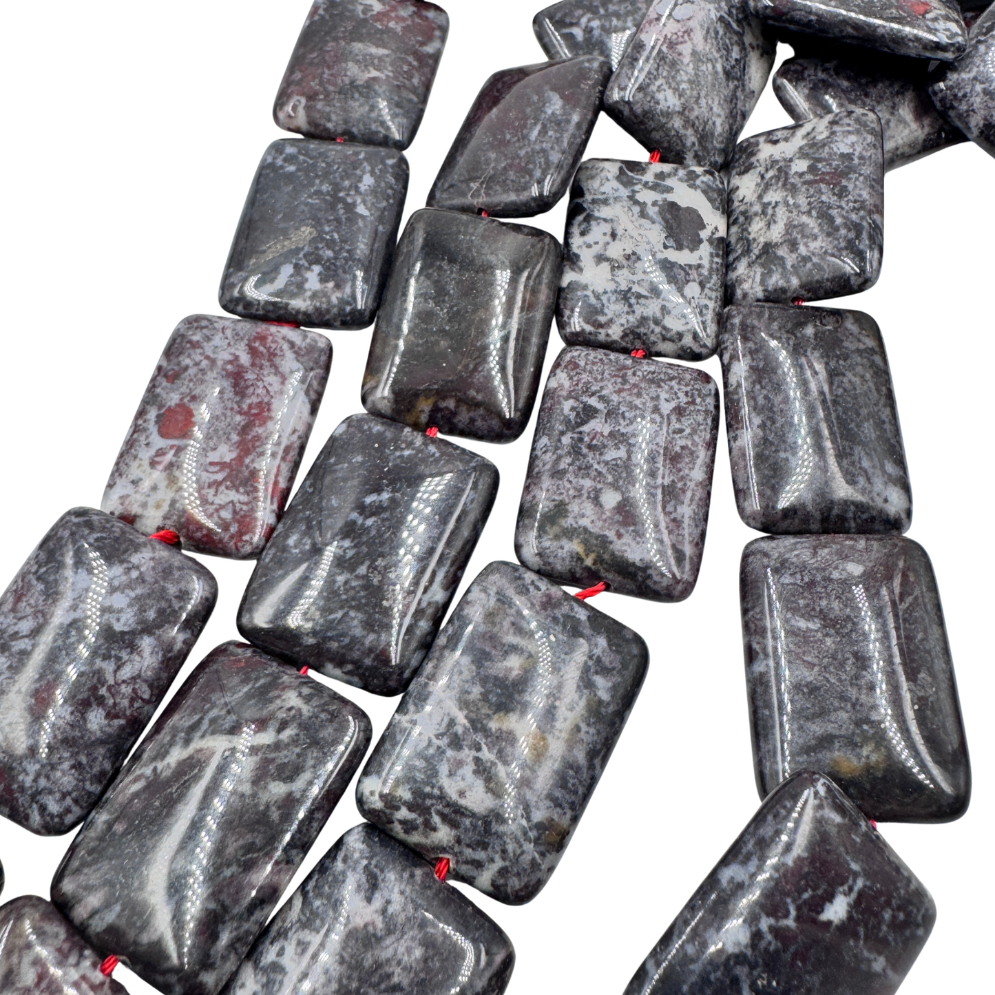 Primo piano delle perle in Blood Stone Rettangolare (PE0411) che mostra la finitura lucida e la trama unica della gemma con venature rossastre.