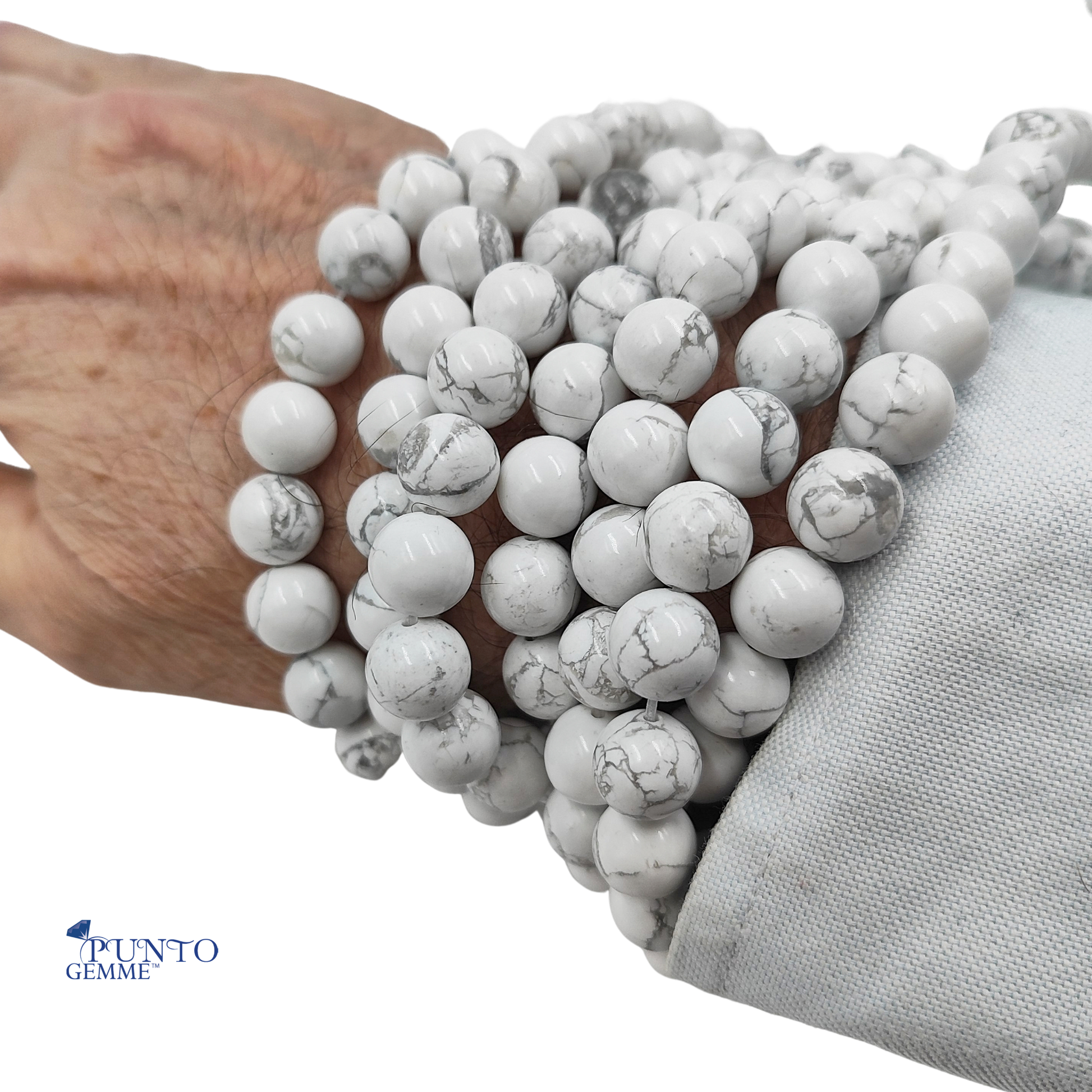 Dettaglio ravvicinato delle perle di Howlite Bianca tonda liscia, evidenziando la finitura lucida e la purezza del bianco. PE0420-10