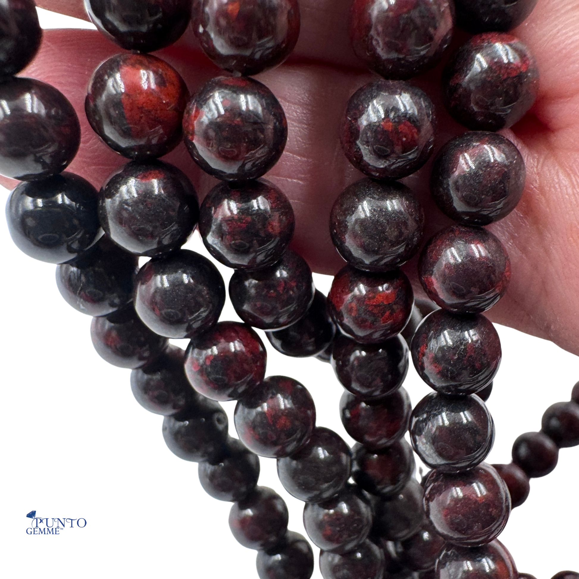 Dettaglio ravvicinato delle perle in Diaspro Poppy che mostra il pattern e la finitura lucida 6 mm.