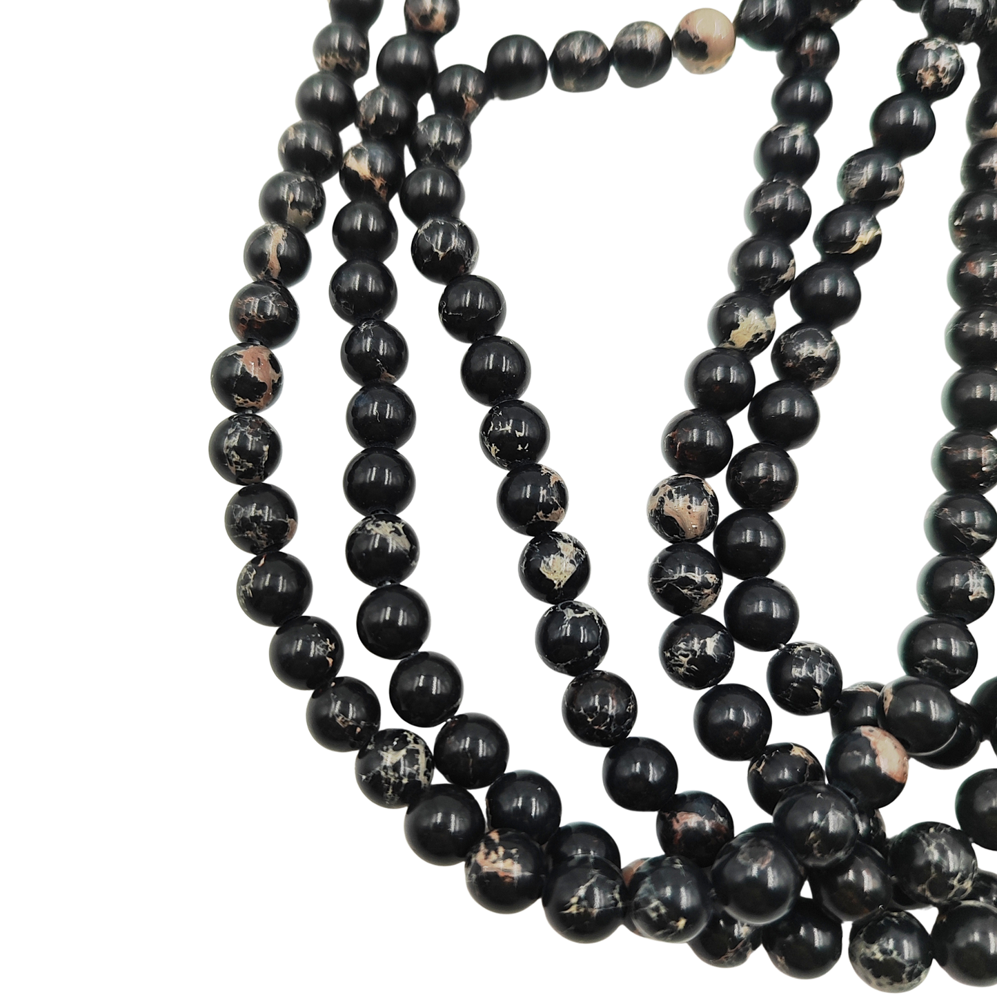 Primo piano del filo di Diaspro Imperiale Nero, perle lisce 6 mm, che mostrano il colore nero intenso e le venature chiare.