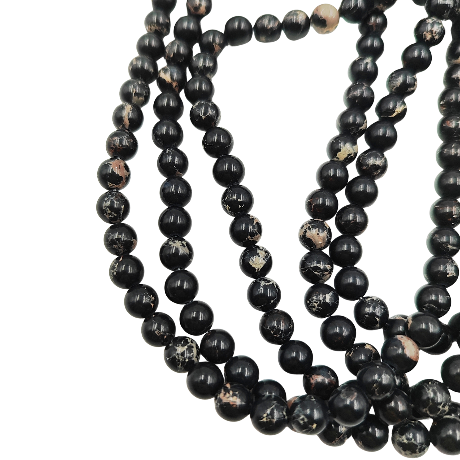 Primo piano del filo di Diaspro Imperiale Nero, perle lisce 6 mm, che mostrano il colore nero intenso e le venature chiare.