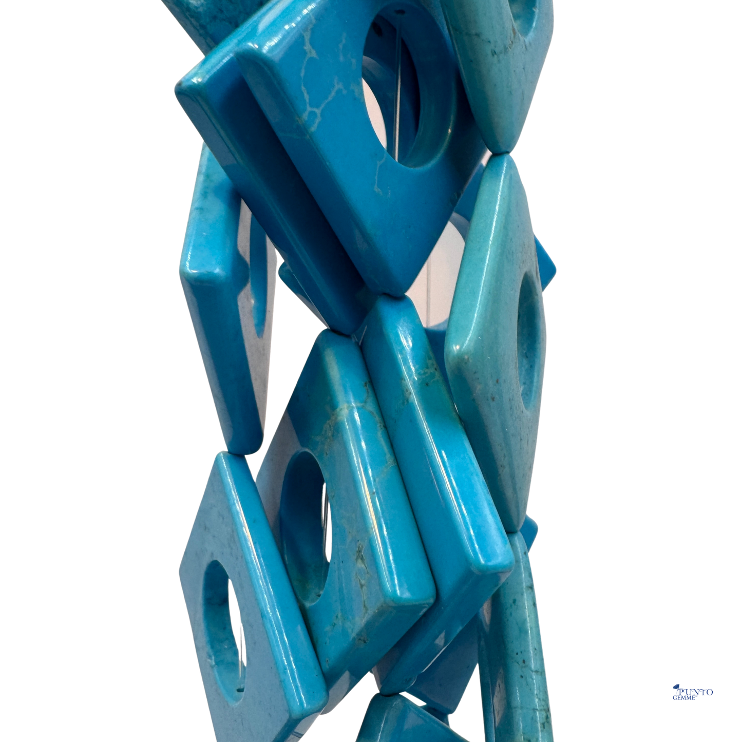 Dettaglio di una singola perla Rombo in Turchese stabilizzato 40x40 mm, che mostra la finitura lucida e il foro centrale.