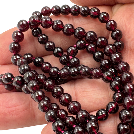 Dettaglio ravvicinato delle perle in Granato Rosso (5,5 mm), che evidenzia la finitura lucida e la qualità TOP 100.