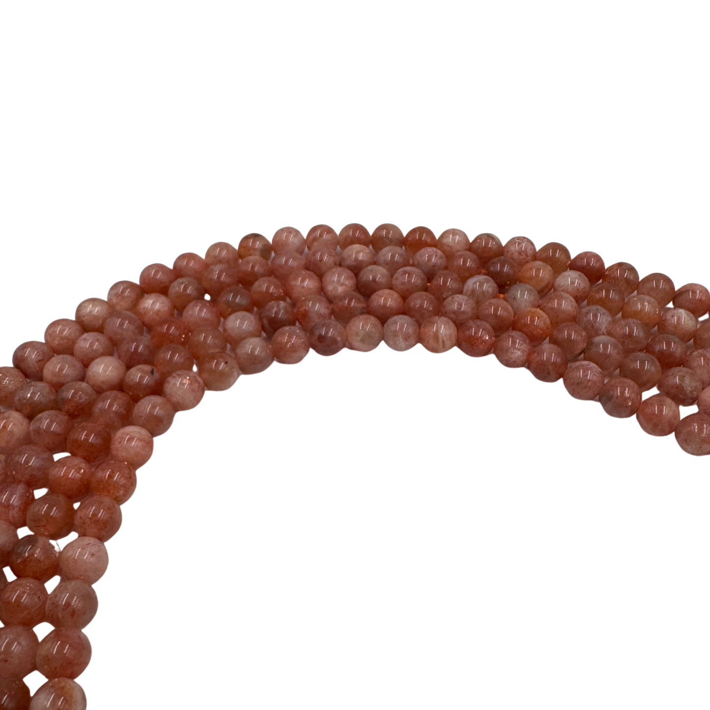 Primo piano del filo di Pietra del Sole, perle tonde lisce 6 mm, che mostrano il colore arancione e i riflessi dorati.