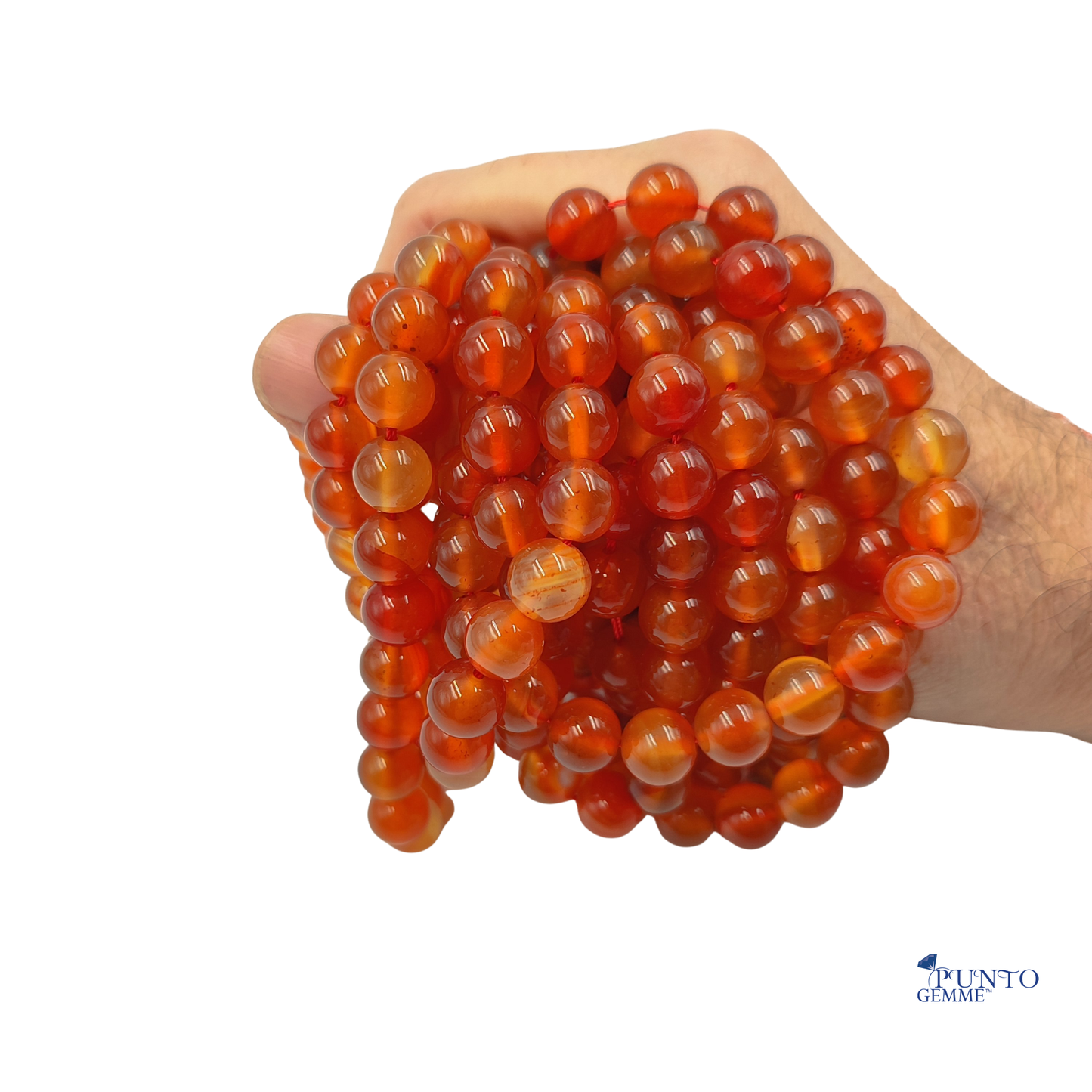 Dettaglio macro delle perle di Corniola tonda liscia, evidenziando la traslucentezza e la superficie lucida.