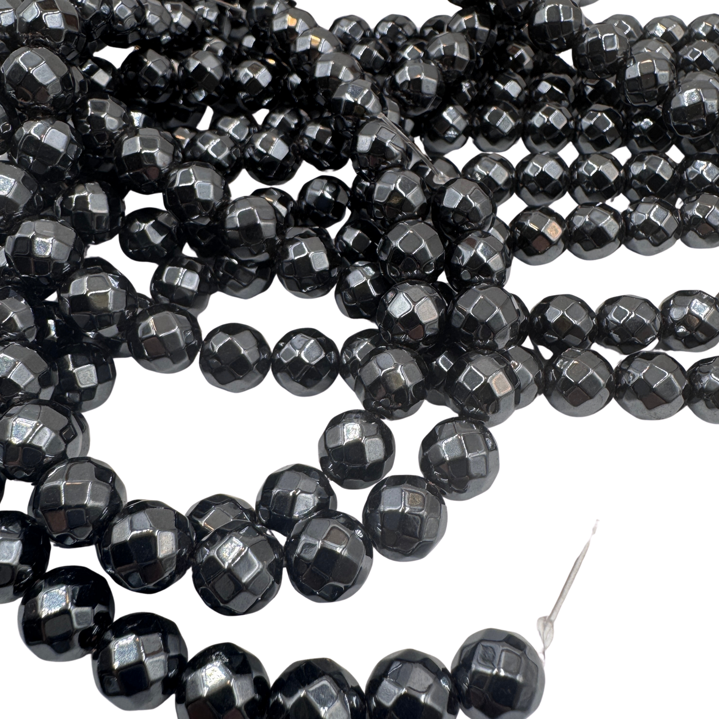 Primo piano del filo di Onice Nero 8mm sfaccettato, che mostra le brillanti sfaccettature nere (TOP 100).