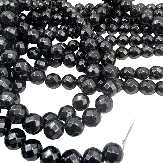 Primo piano del filo di Onice Nero 8mm sfaccettato, che mostra le brillanti sfaccettature nere (TOP 100).