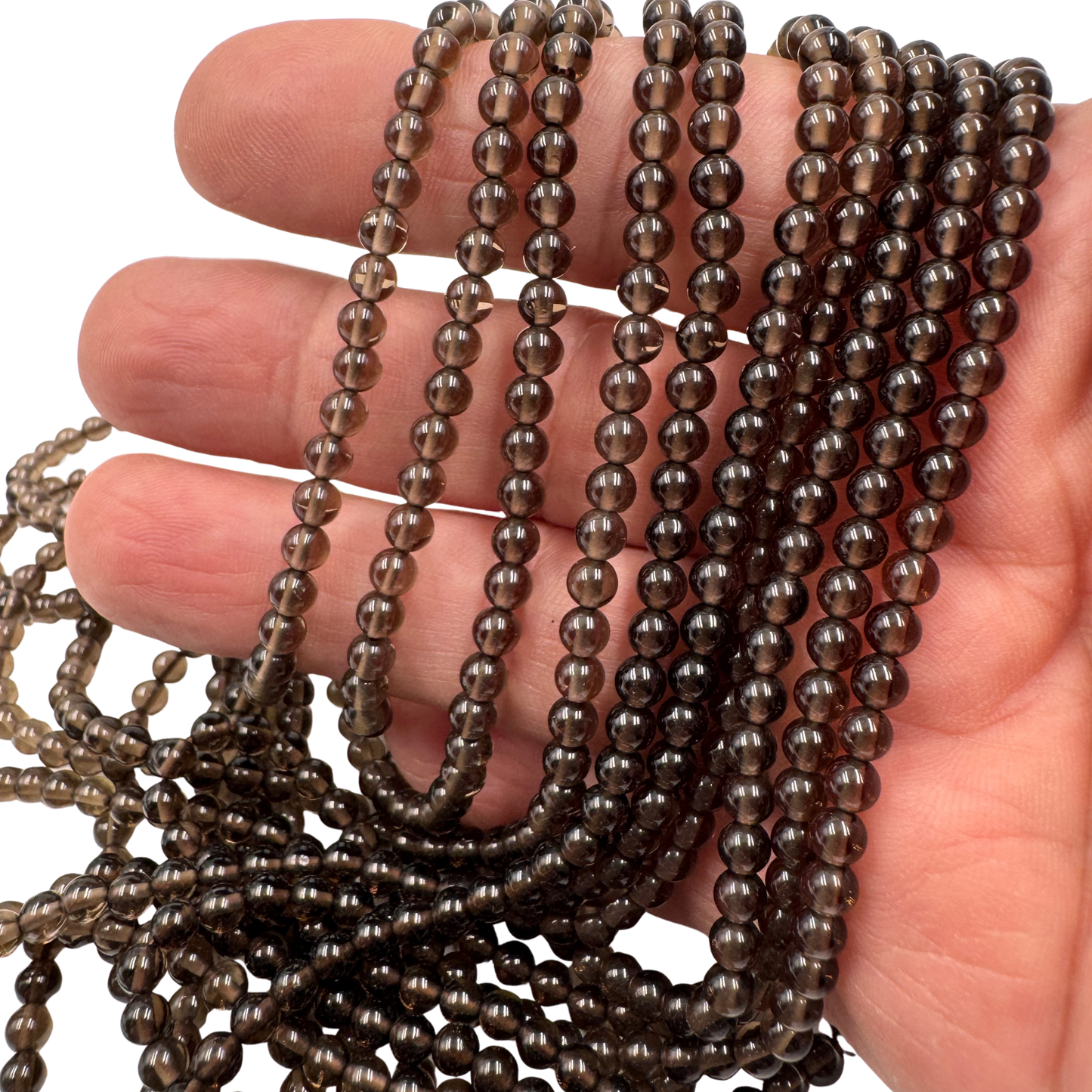 Dettaglio ravvicinato delle perle in Quarzo Fumè (PE0781-04) di 4 mm, che evidenzia la finitura lucida e la qualità AA 