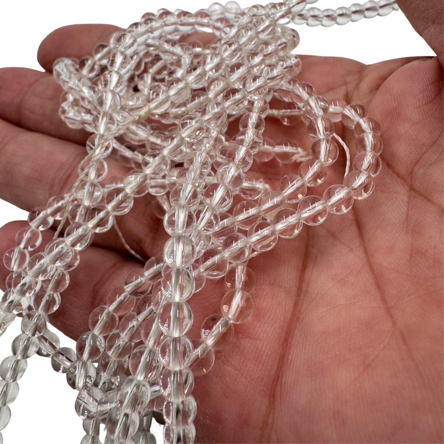 Dettaglio ravvicinato delle perle in Quarzo Ialino (PE0806-04) di 4 mm, che evidenzia la finitura lucida e la purezza perfetta (Grado AA).