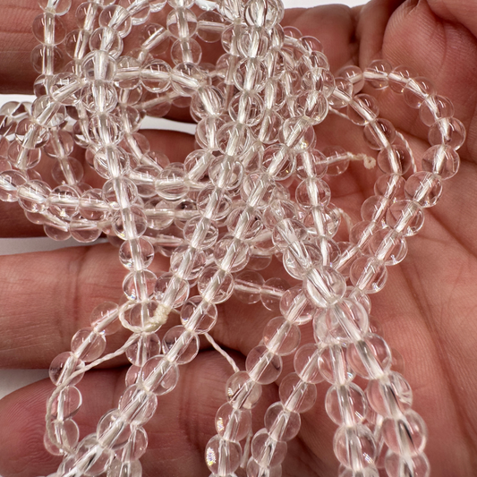 Filo di perle sferiche lisce in Quarzo Ialino (Cristallo di Rocca) Grado AA da 8 mm, che mostra la limpida purezza cristallina.