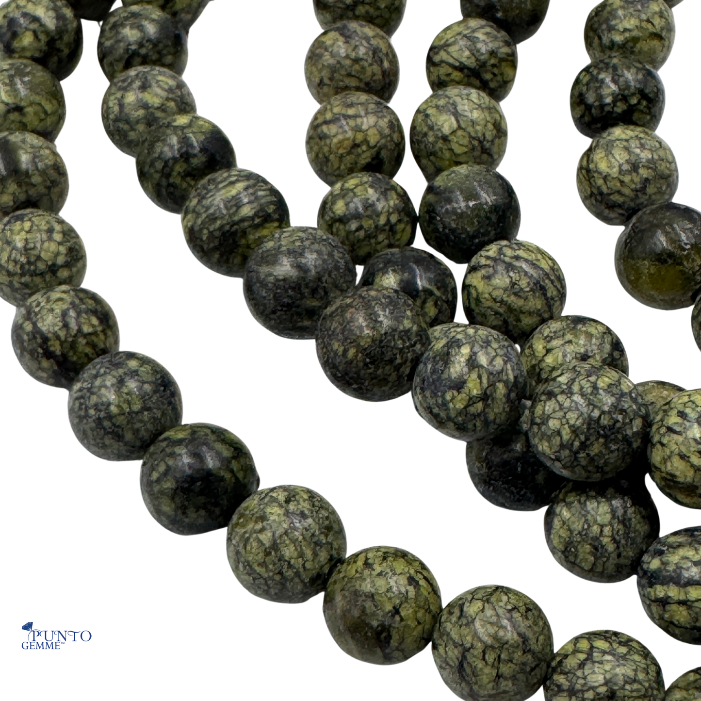 Scatto macro di perle tonde in Giada Russa, la gemma che aiuta a sbloccare il Chakra del Cuore.